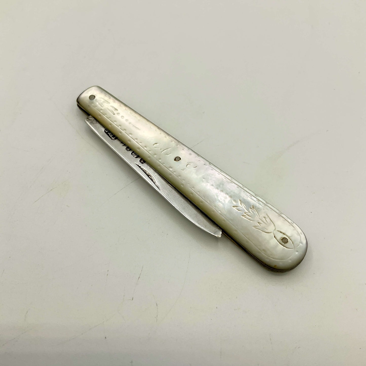 antique silver fruit knife on a light gray background