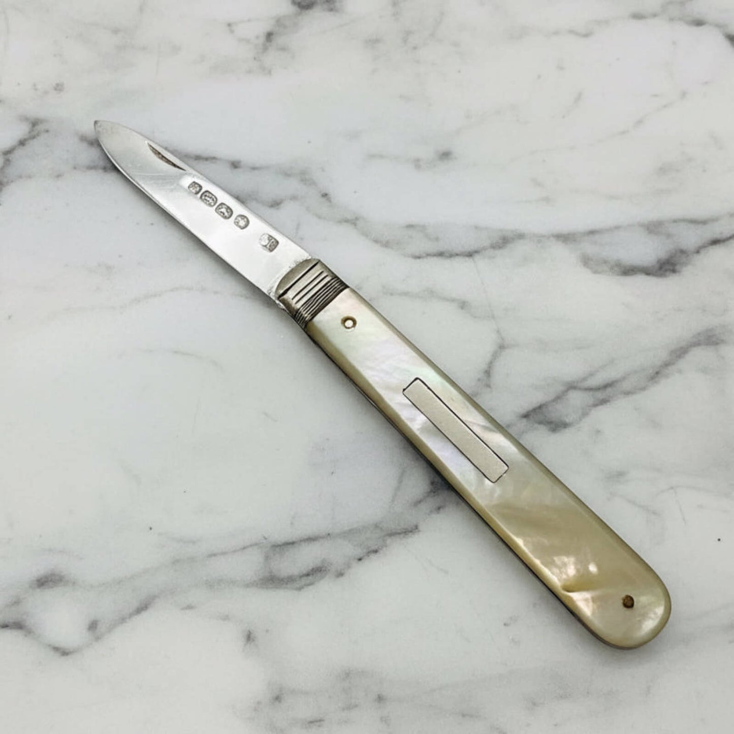 Folding knife with a decorative handle on a marble surface