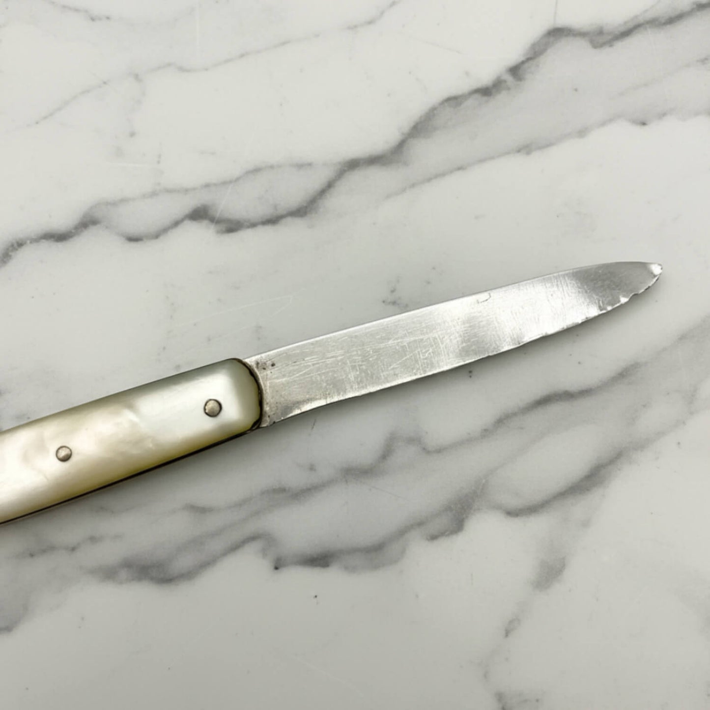 Antique fruit Knife with a decorative handle on a marble surface
