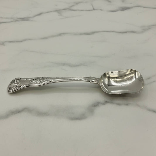 Antique Victorian Sterling Silver Spoon with an ornate handle, resting on a white marble surface with gray veining.