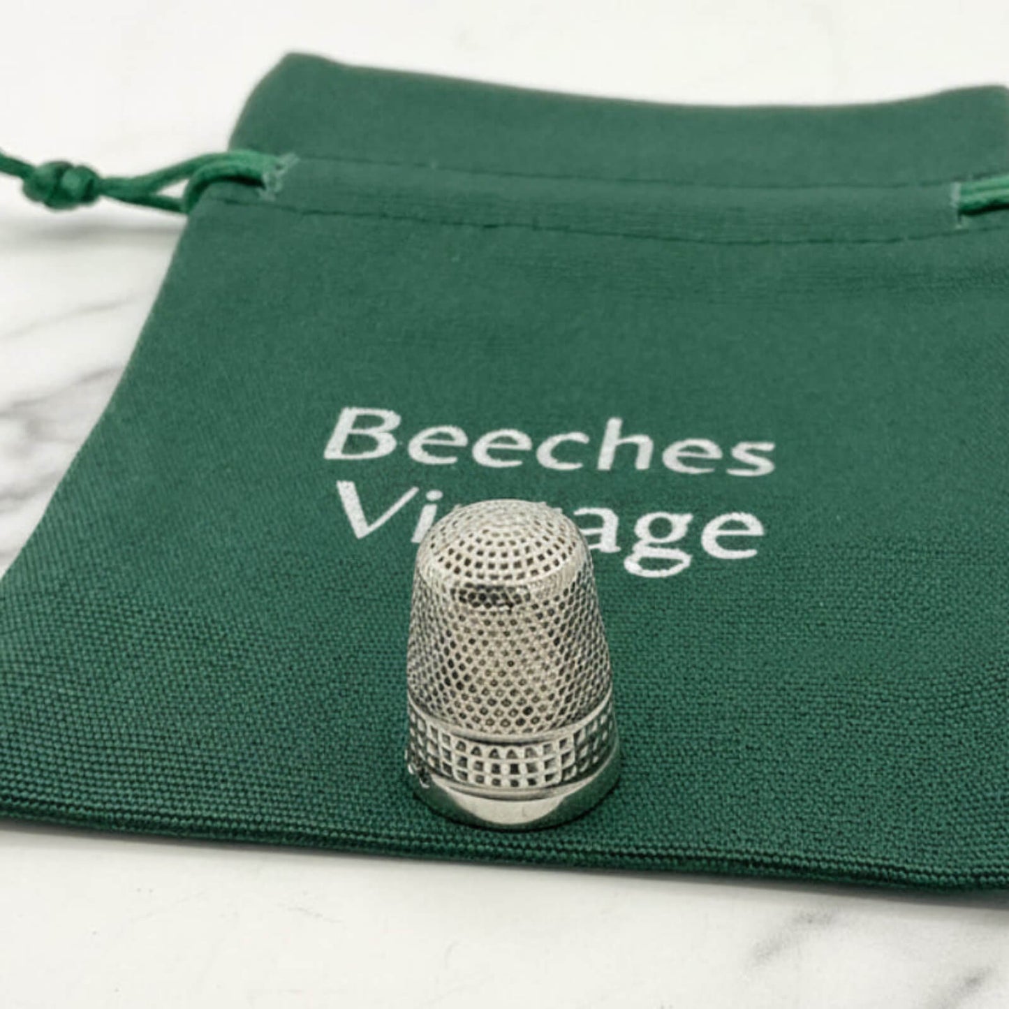 silver thimble on a green bag 