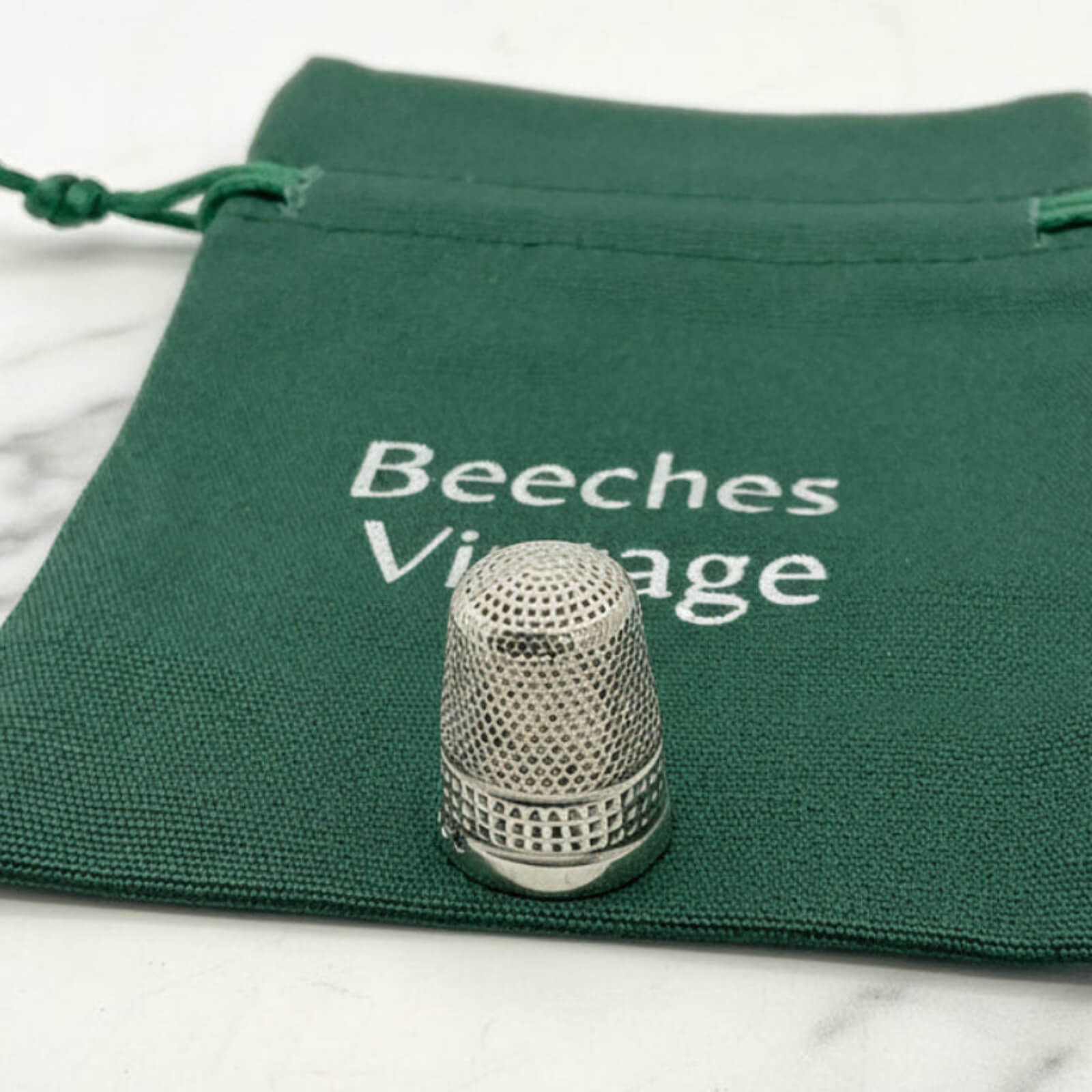 silver thimble on a green bag 