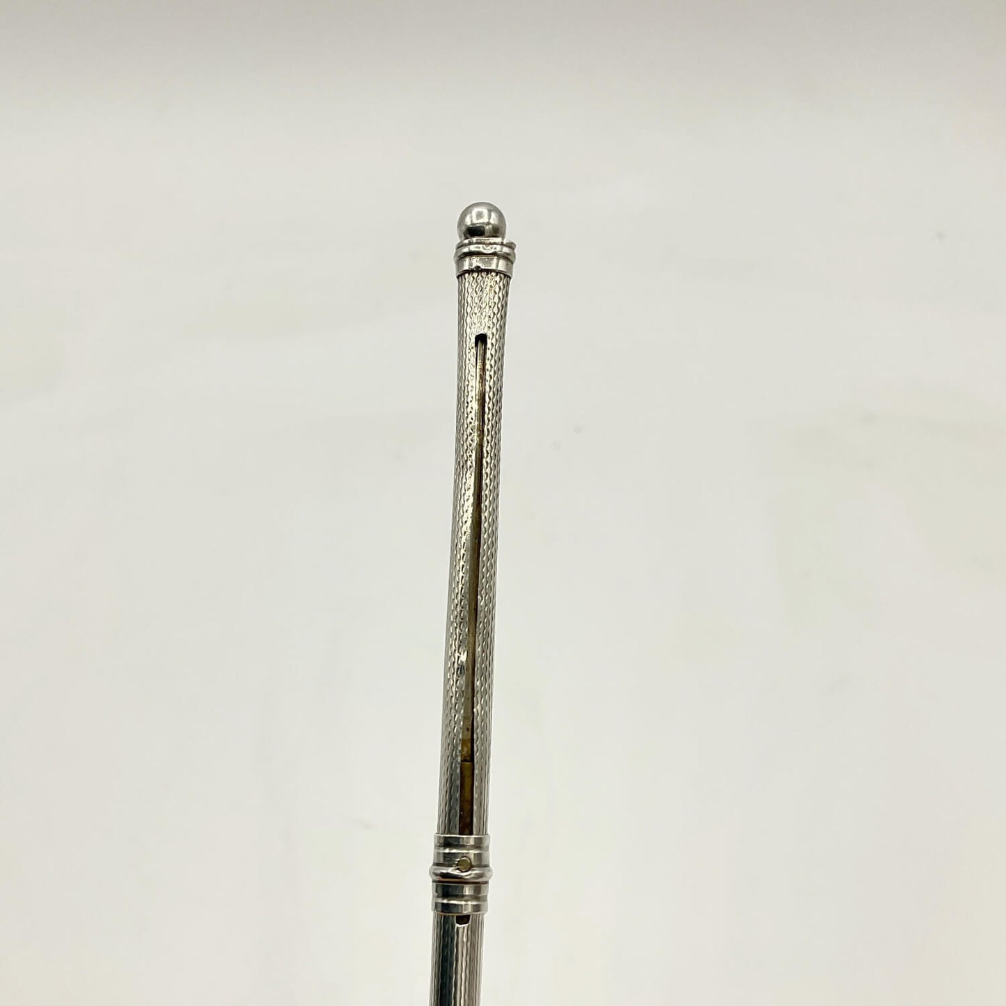 A close-up of a Art Deco Sterling Silver Cocktail Whisk set against a plain off-white background.