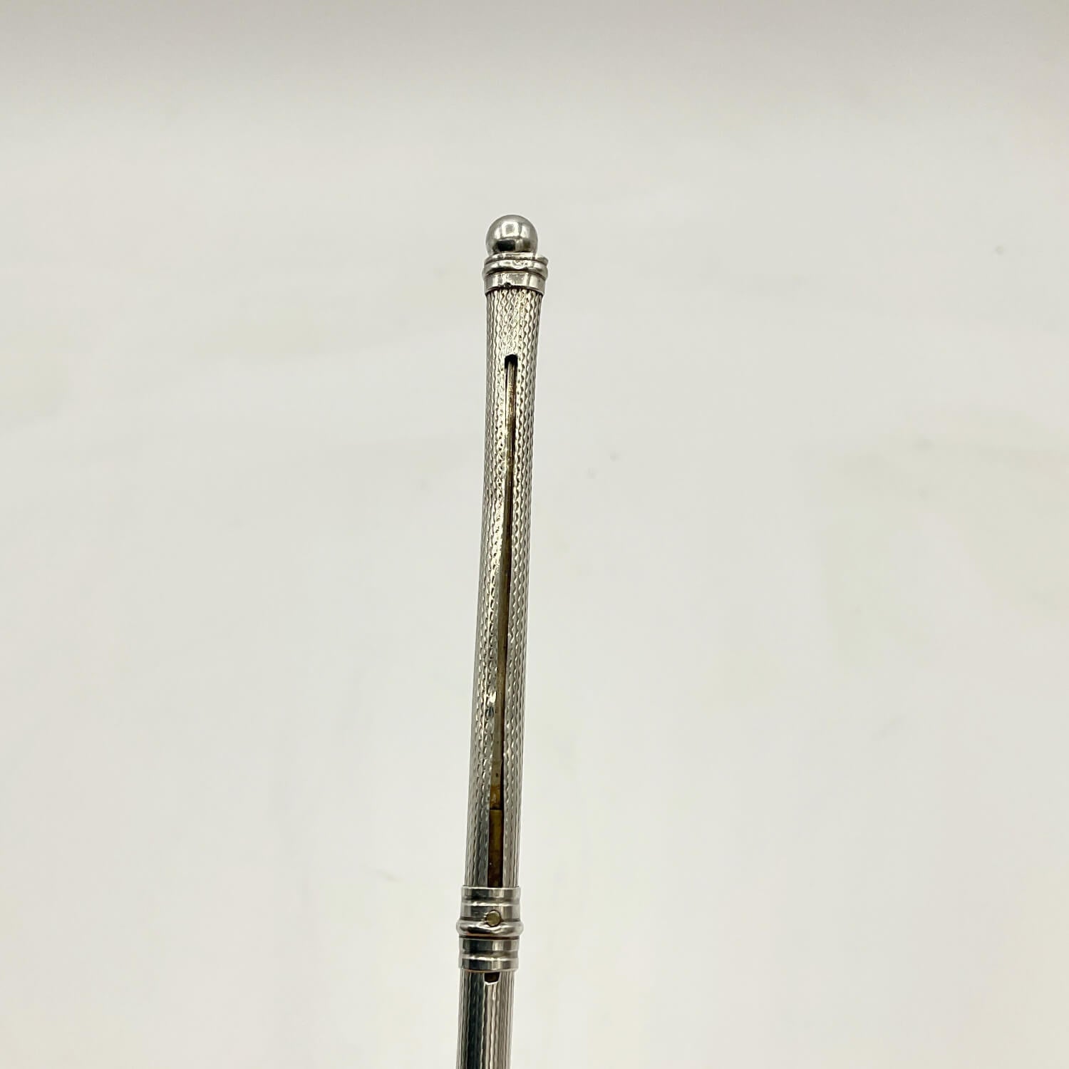 A close-up of a Art Deco Sterling Silver Cocktail Whisk set against a plain off-white background.