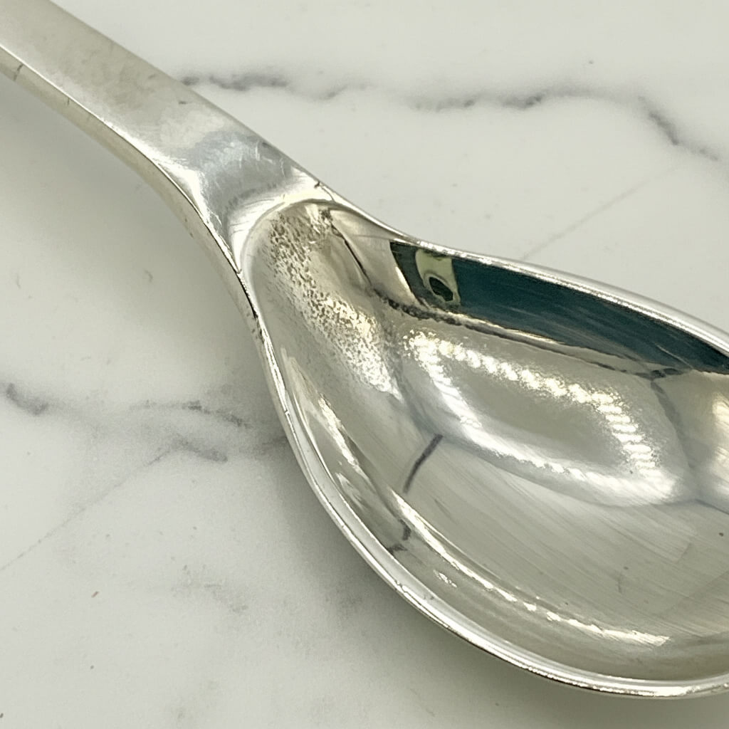 Silver salt spoon on a marble surface