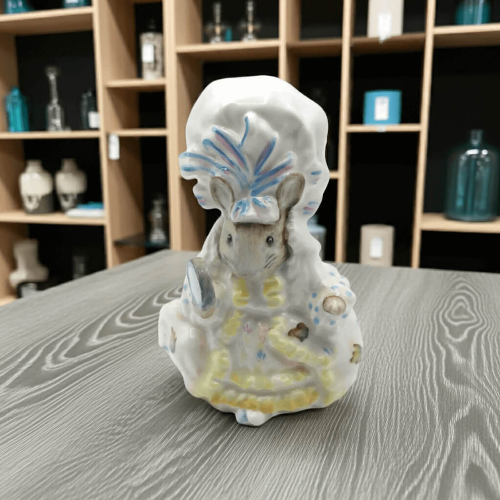 Decorative figurine of a mouse with a headdress on a wooden surface