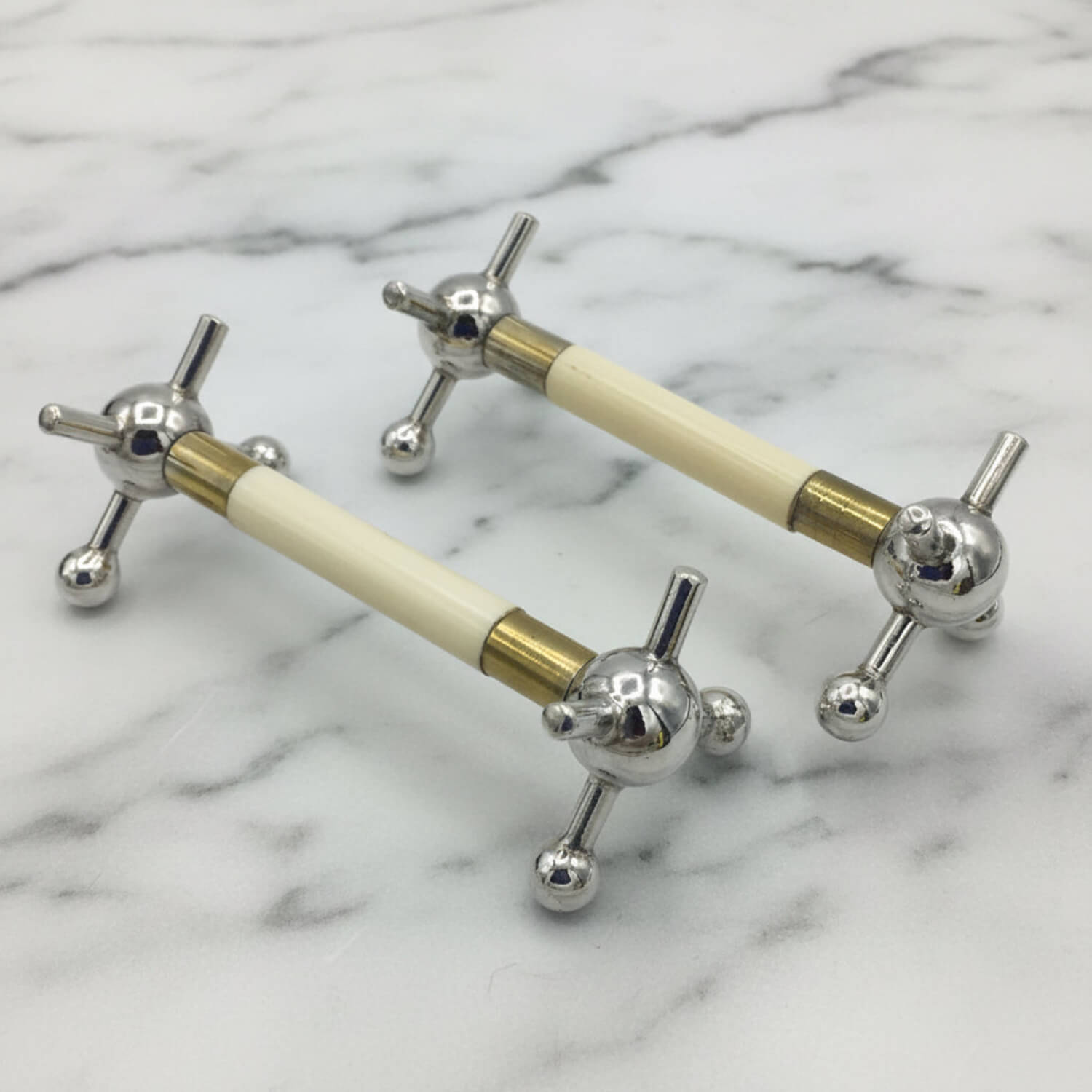 Pair of Antique Silver Plated Knife Rests on a marble surface
