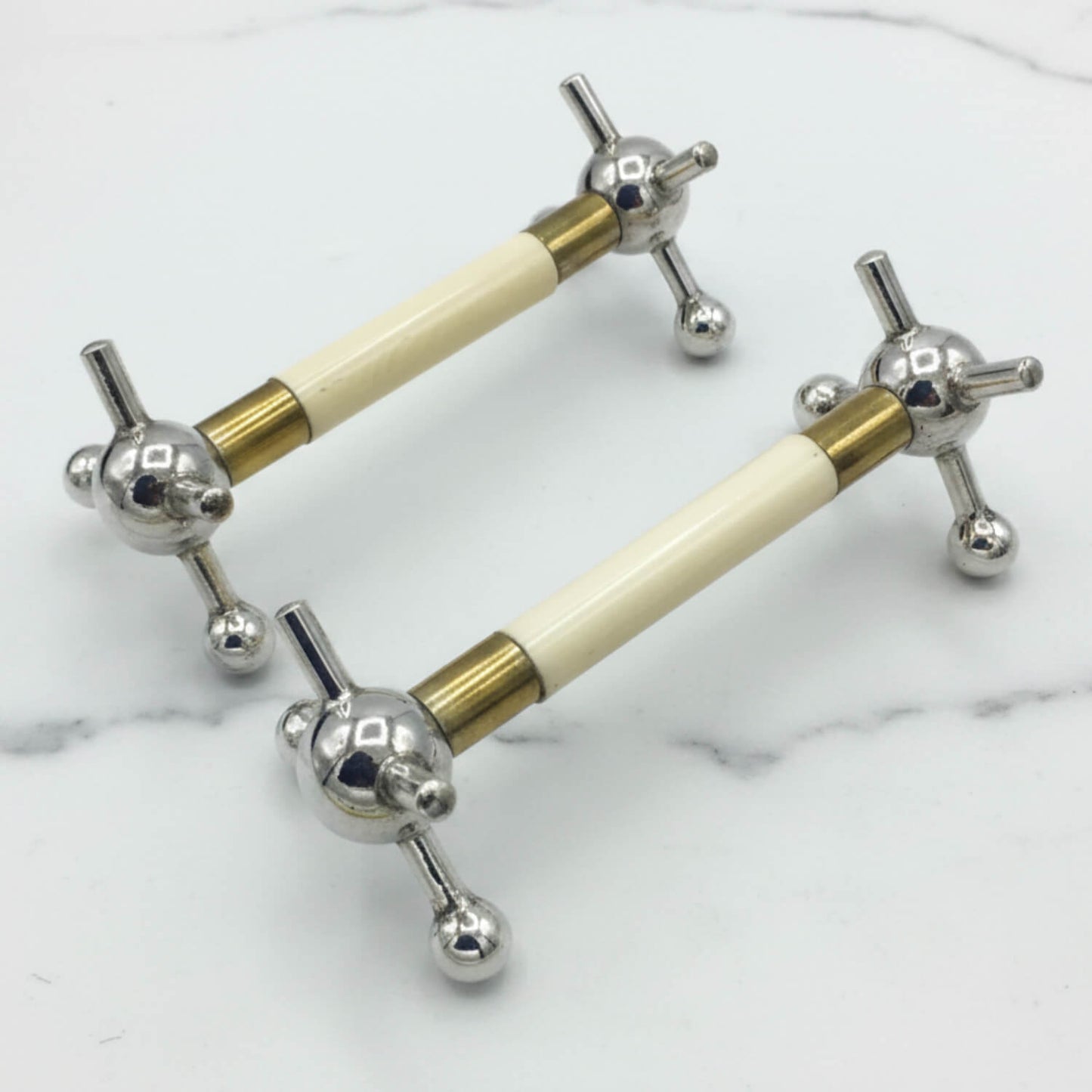 Pair of Antique Silver Plated Knife Rests on a marble surface