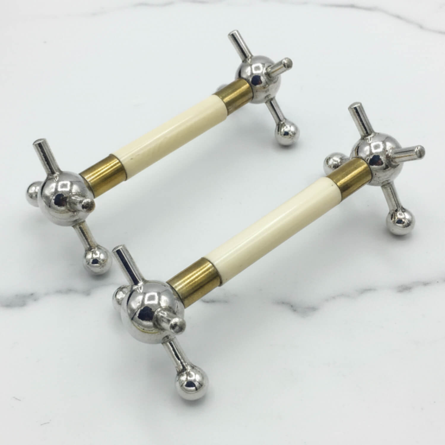 Pair of Antique Silver Plated Knife Rests on a marble surface