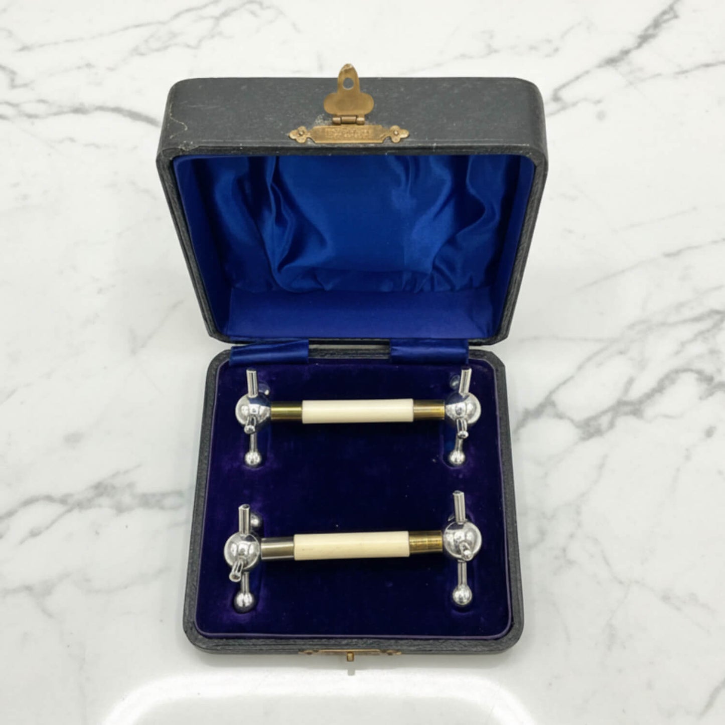 Boxed Pair of Antique Silver Plated Knife Rests on a marble surface
