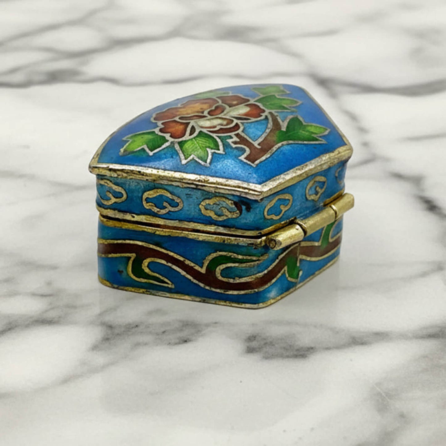 Chinese Cloisonné Enamel Pill Box side view showing hinge back on a marble surface