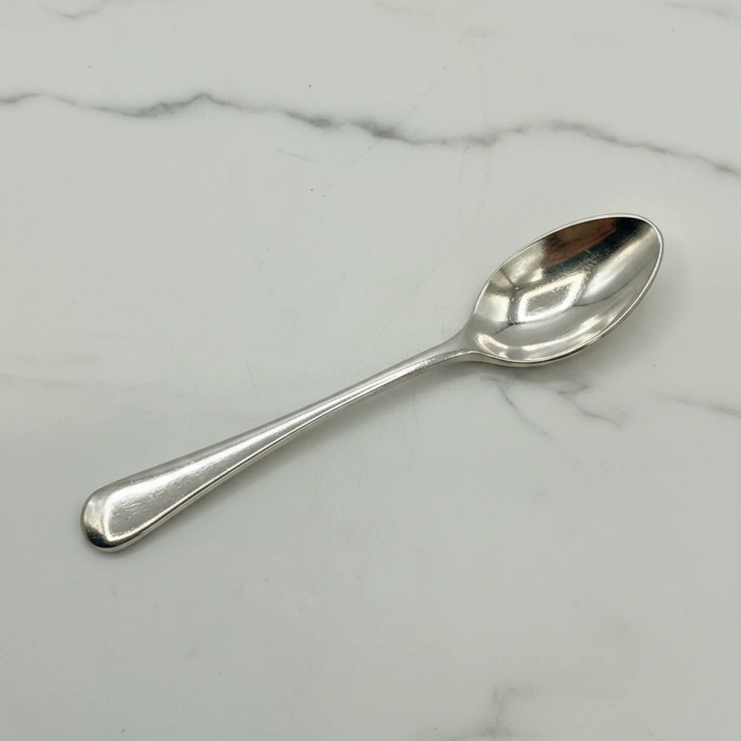 Silver coffee spoon on a marble surface
