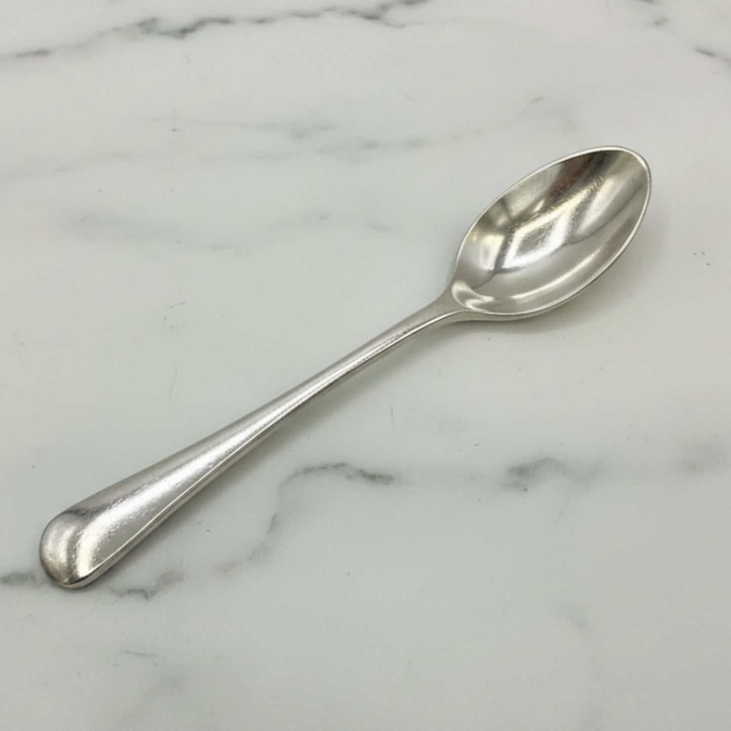 Silver coffee spoon on a marble surface