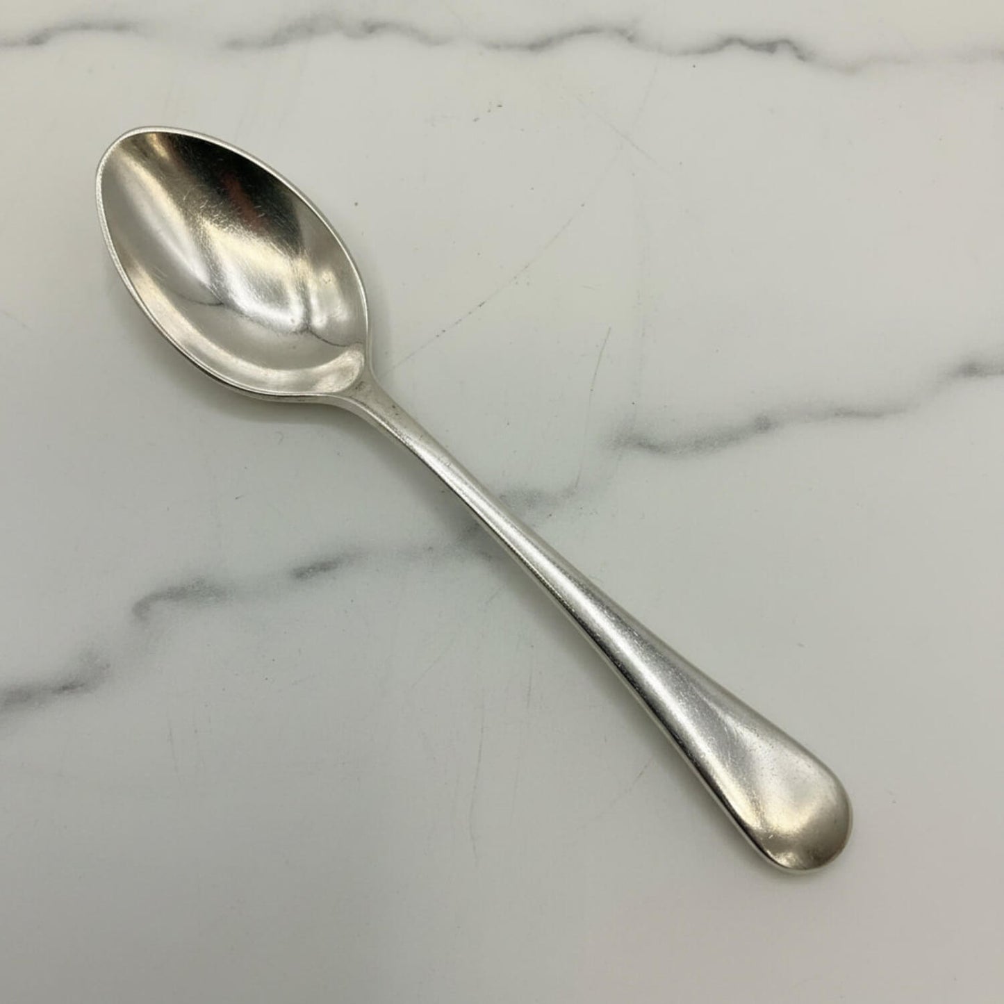 Silver coffee spoon on a marble surface
