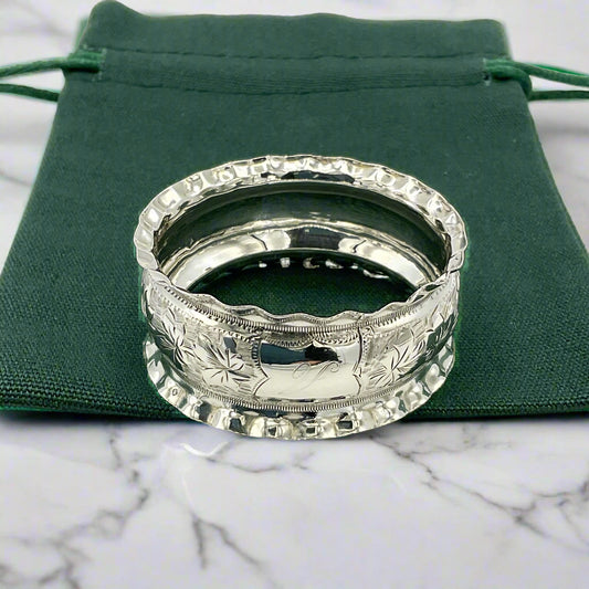 Silver napkin ring on green gift bag on marble worktop