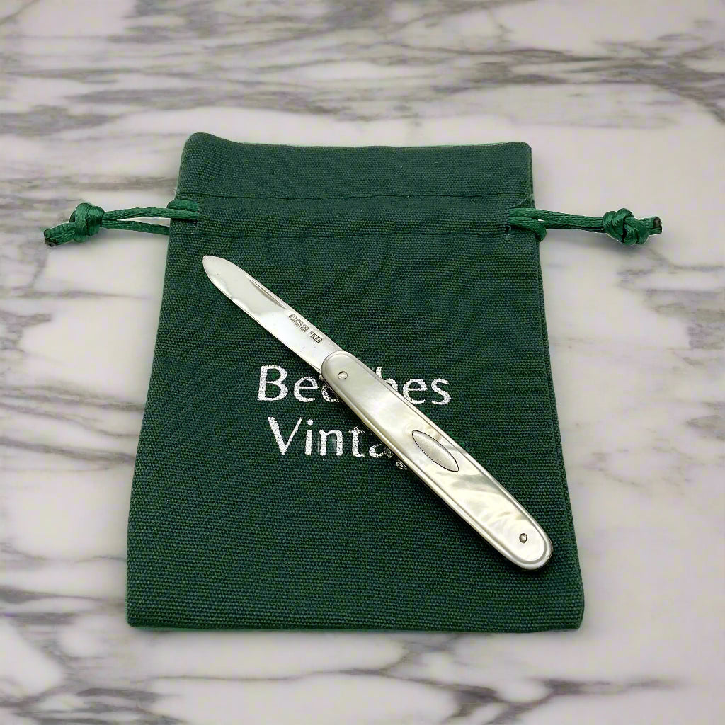 Silver fruit knife on a green drawstring bag with 'Beeches Vintage' branding.