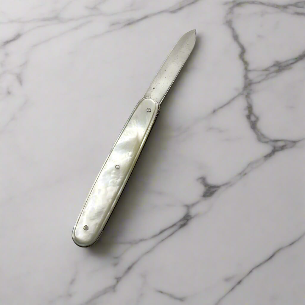 Silver fruit knife on a marble surface