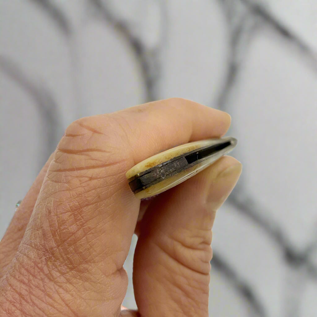Hand showing the end of the fruit knife against a marble background
