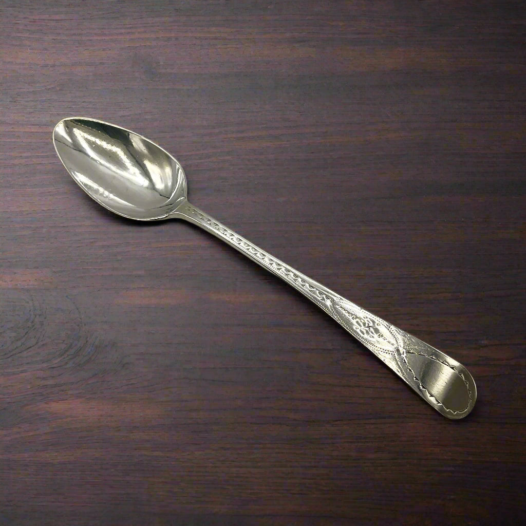 Silver spoon on a dark wood table