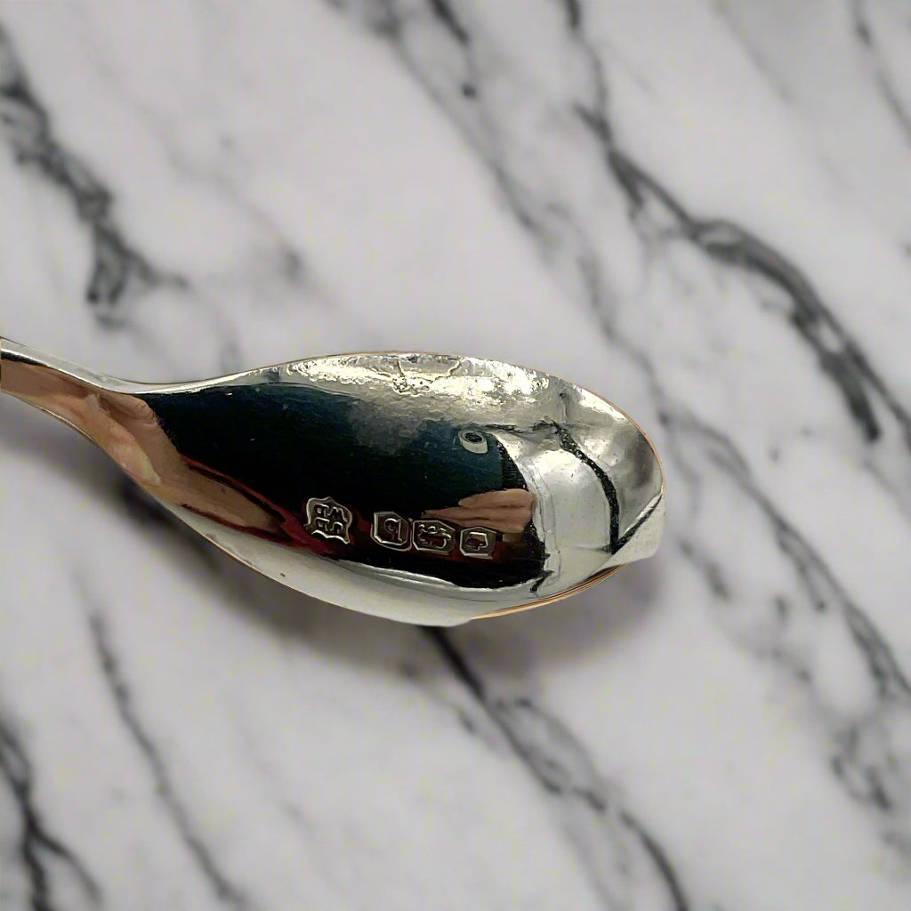 Silver spoon with visible hallmark on a marble worktop