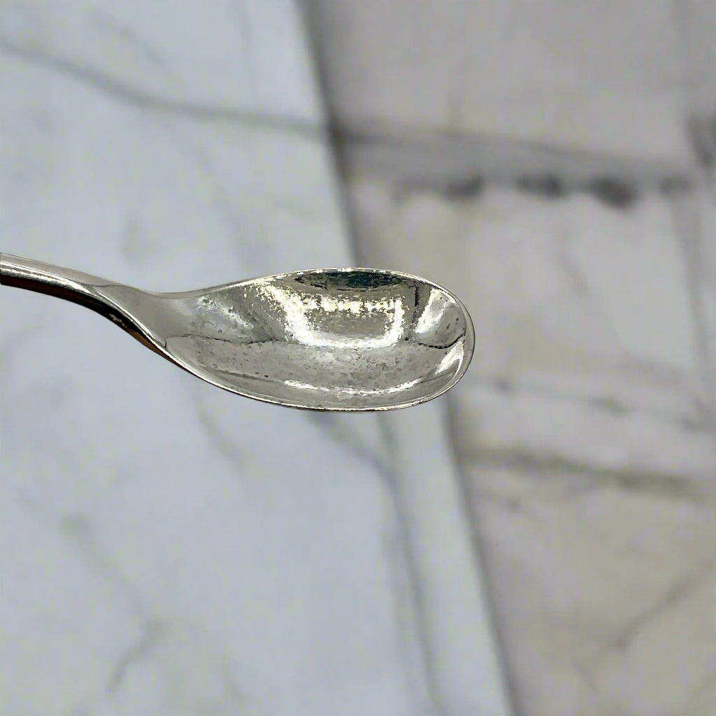 Silver spoon on a marble surface with a blurred background