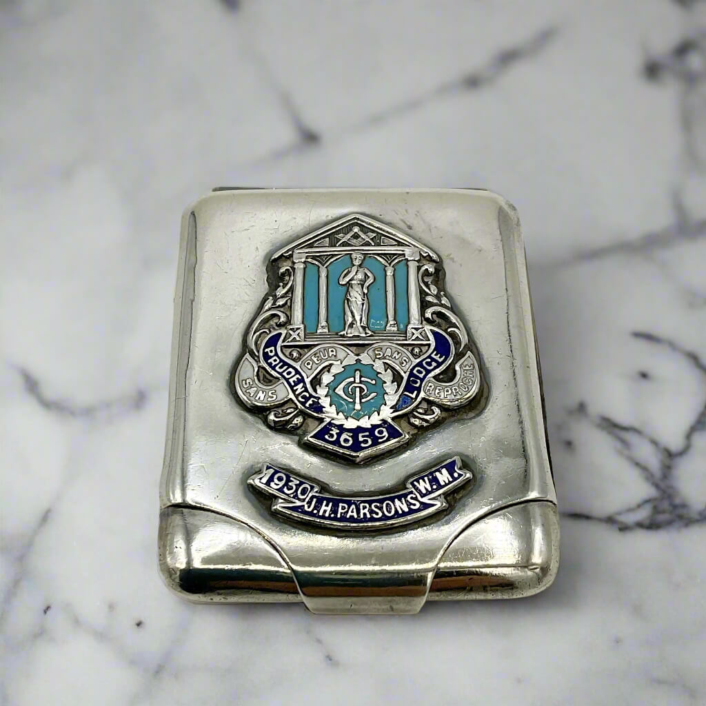 Silver matchbook case with Masonic emblem on a marble worktop