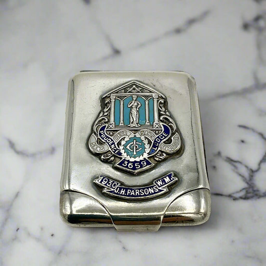 Silver matchbook case with Masonic emblem on a marble worktop