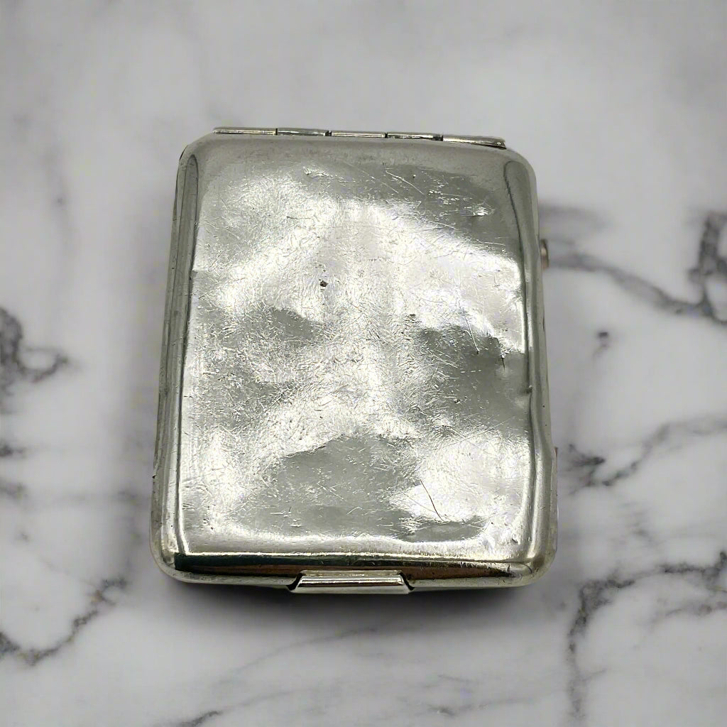 Silver matchbook case on a light marble background