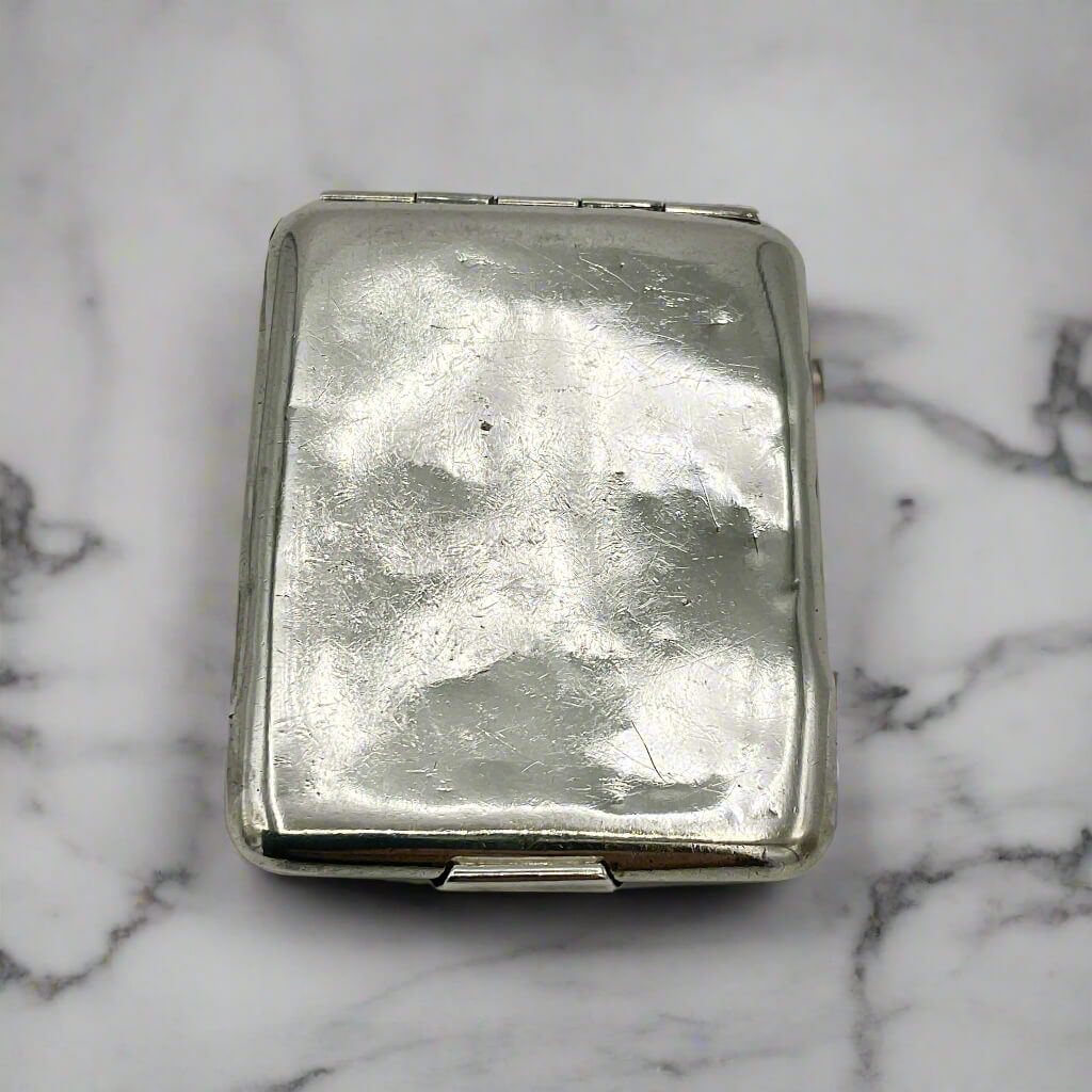 back of silver matchbook case on a marble surface