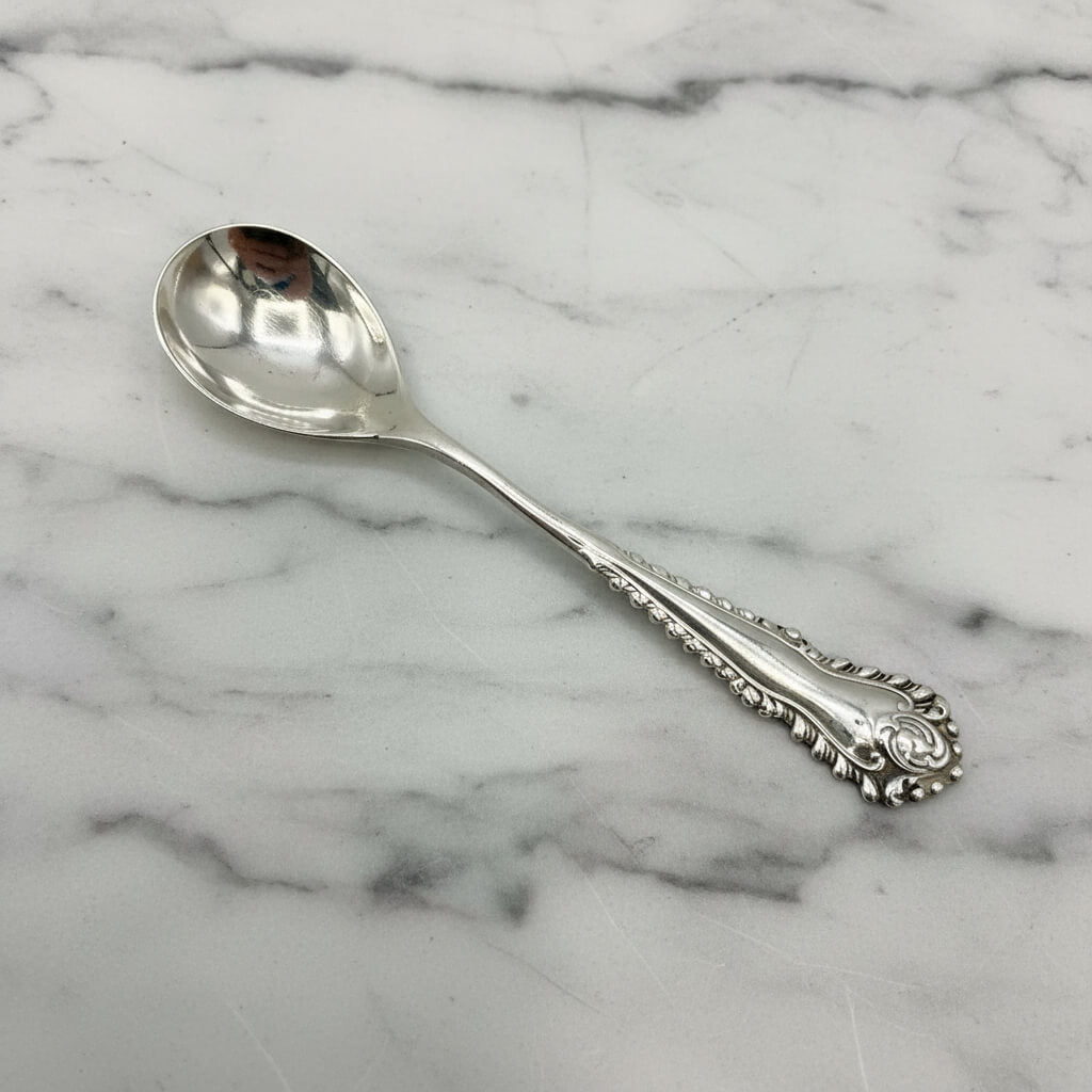 Silver spoon with intricate designs on a marble background