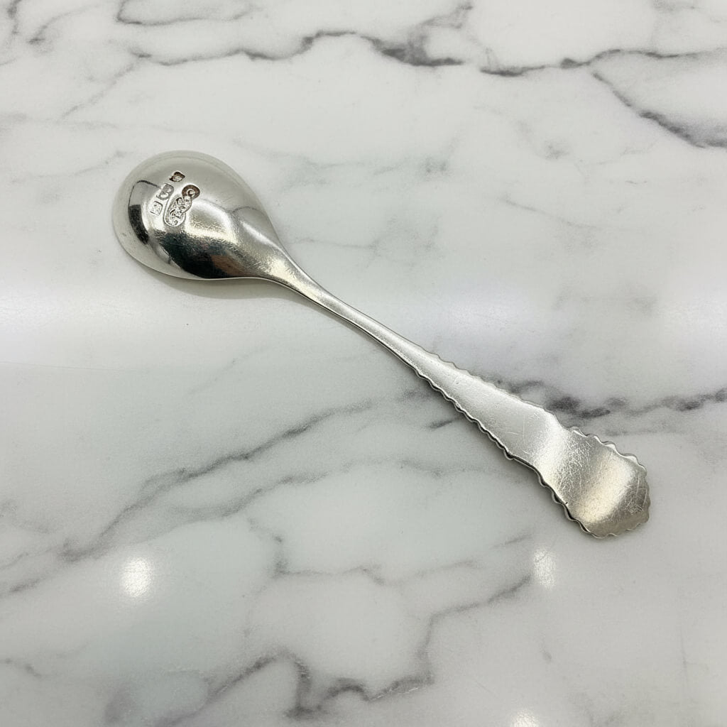 back of Silver spoon on a marble background