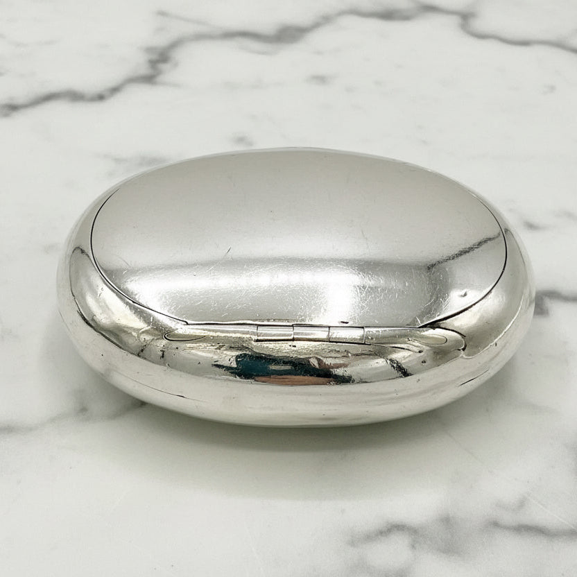 Silver oval box on a marble surface
