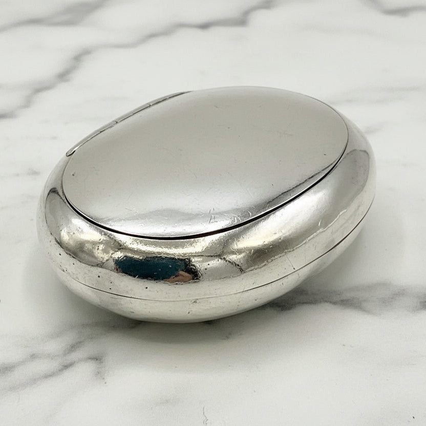 Silver oval box on a marble surface
