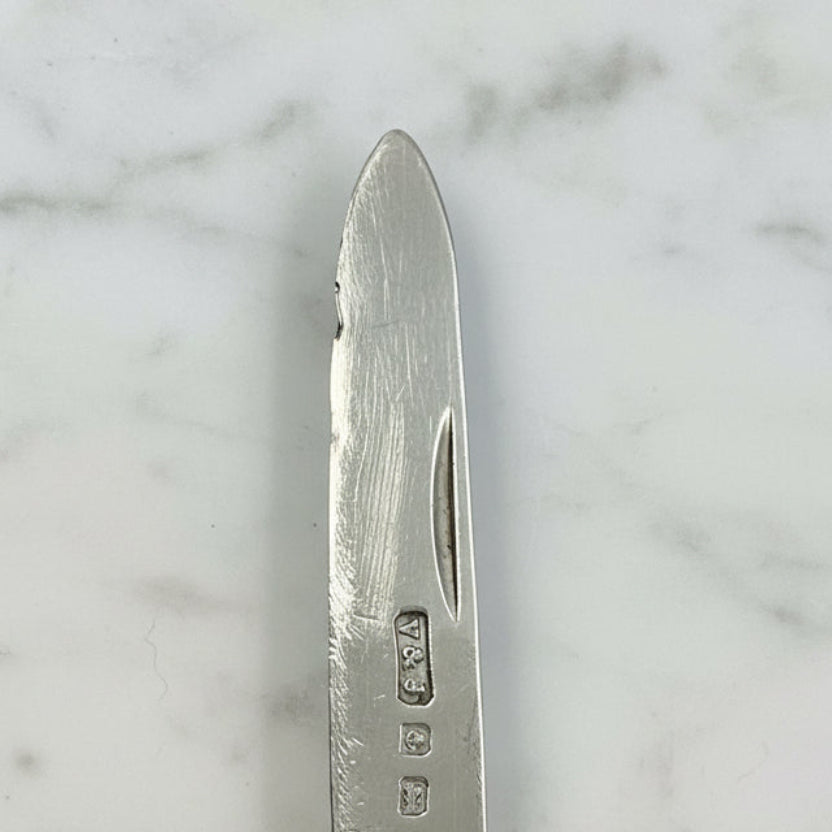 Close-up of a silver knife blade on a marble background