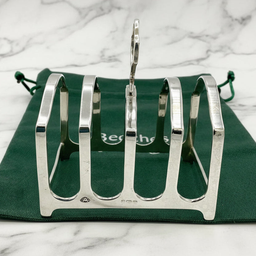 Silver toast rack on a green cloth bag with 'Beeches Vintage' branding against a marble background