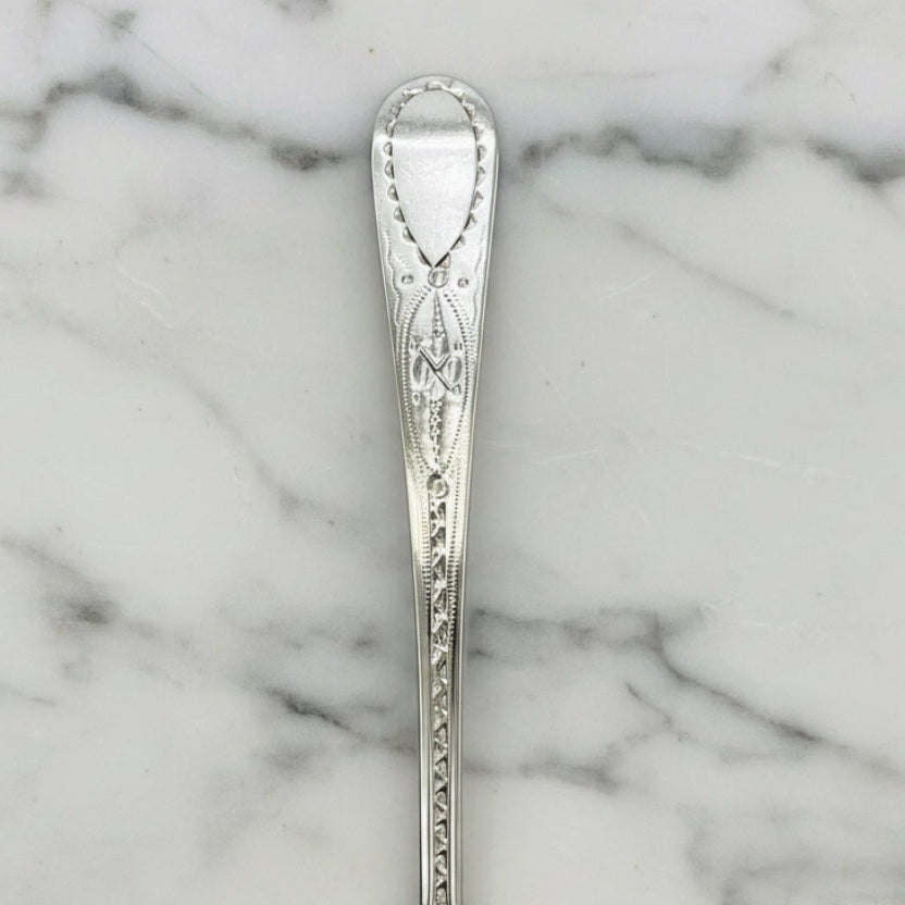 Decorative silver spoon handle on a marble worktop