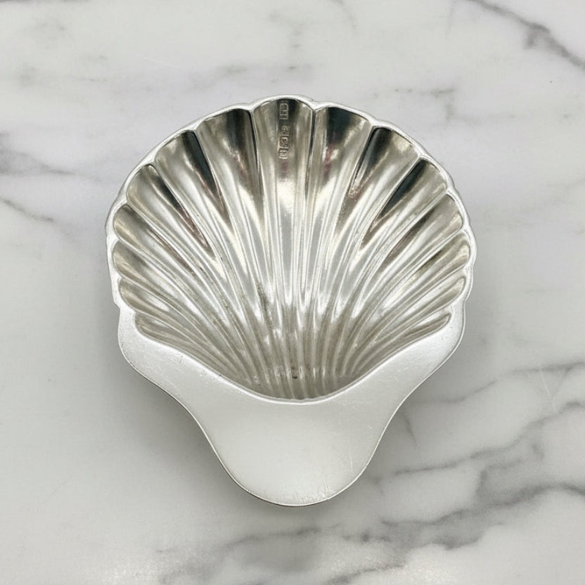 Silver shell-shaped bowl on a marble background