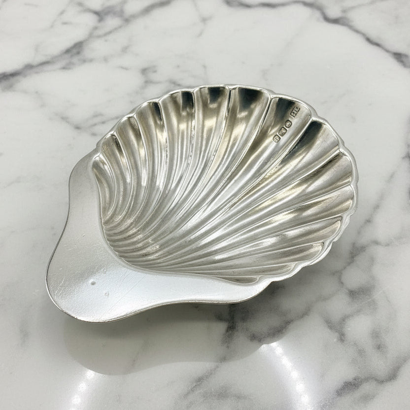 Silver shell-shaped dish on a marble surface