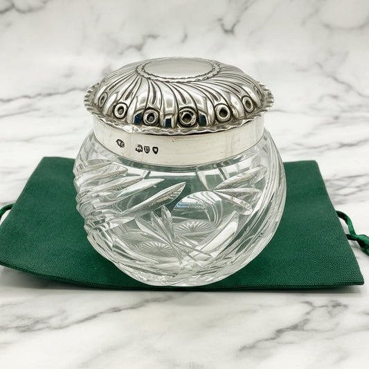 Clear glass jar with silver lid on a green cloth