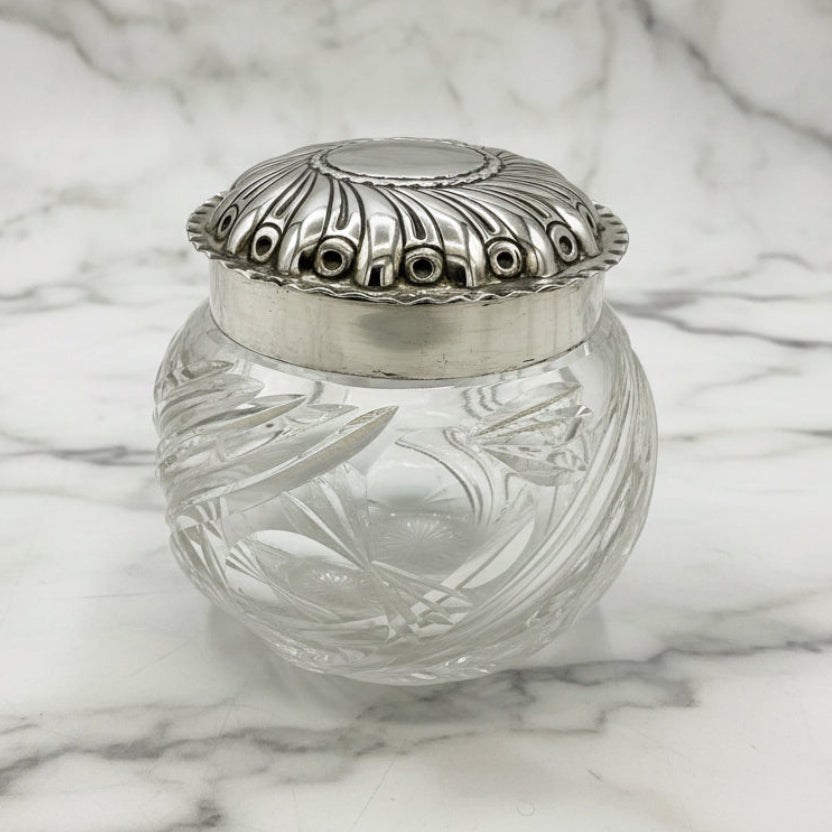 Clear glass jar with a silver lid on a white background