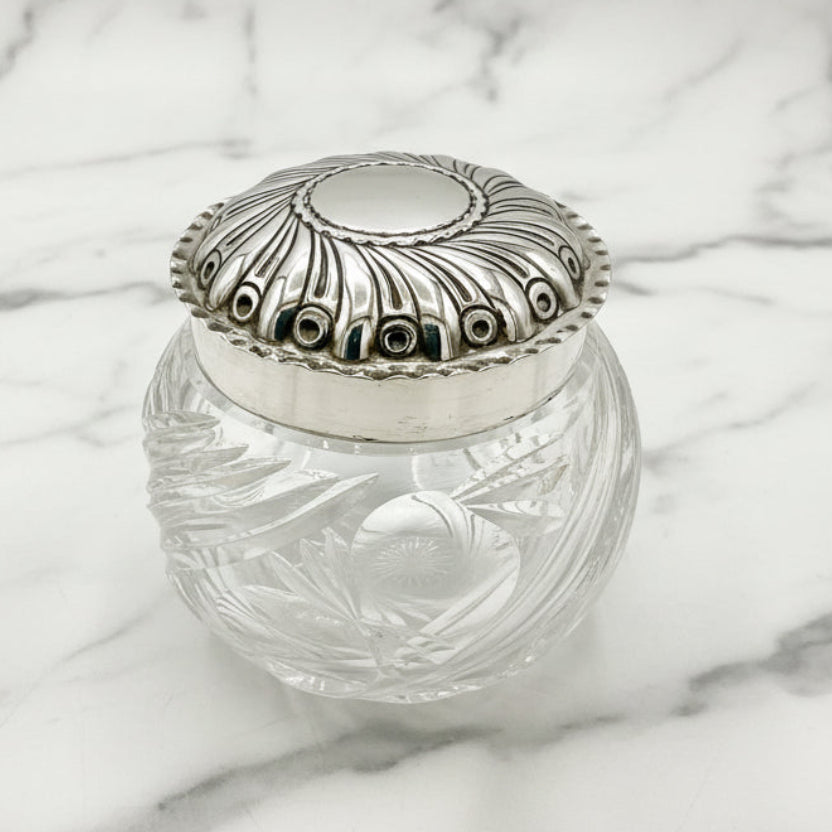 Clear glass jar with a silver lid on a white background