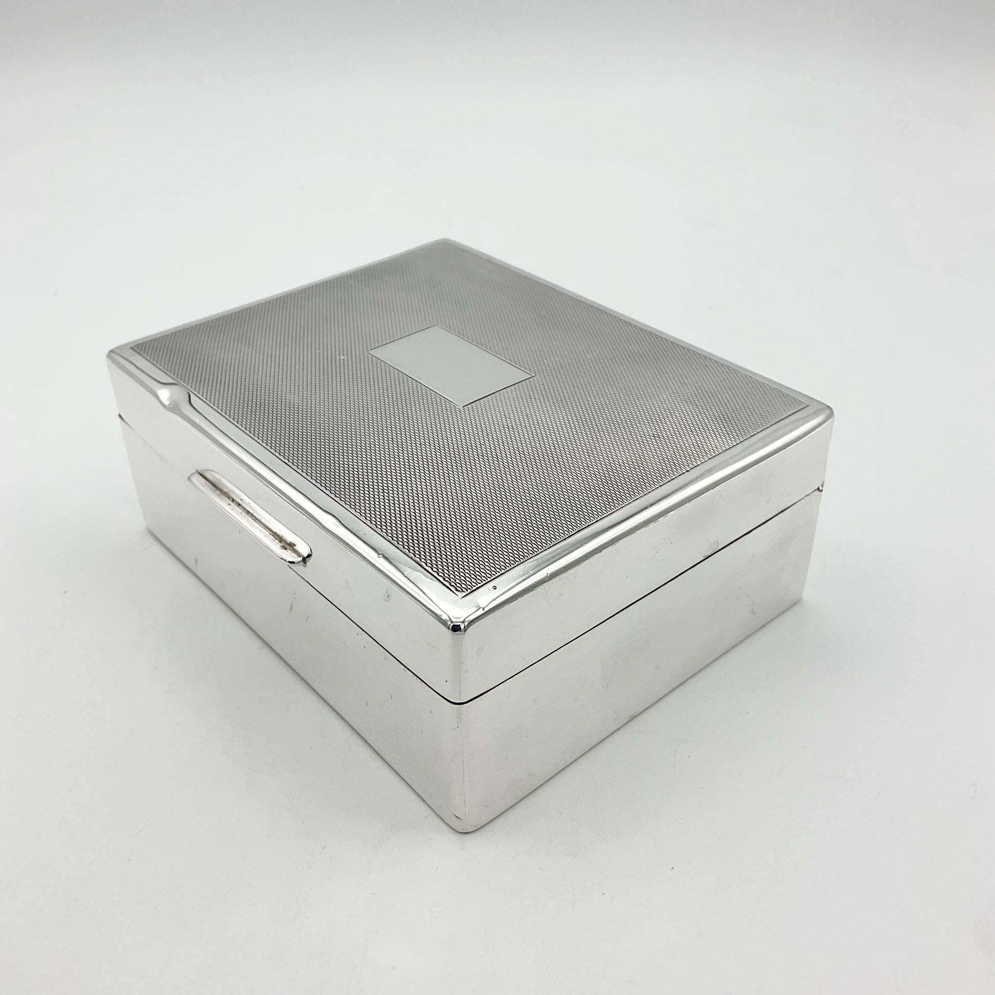 Side view of silver cigar box or case on a white background
