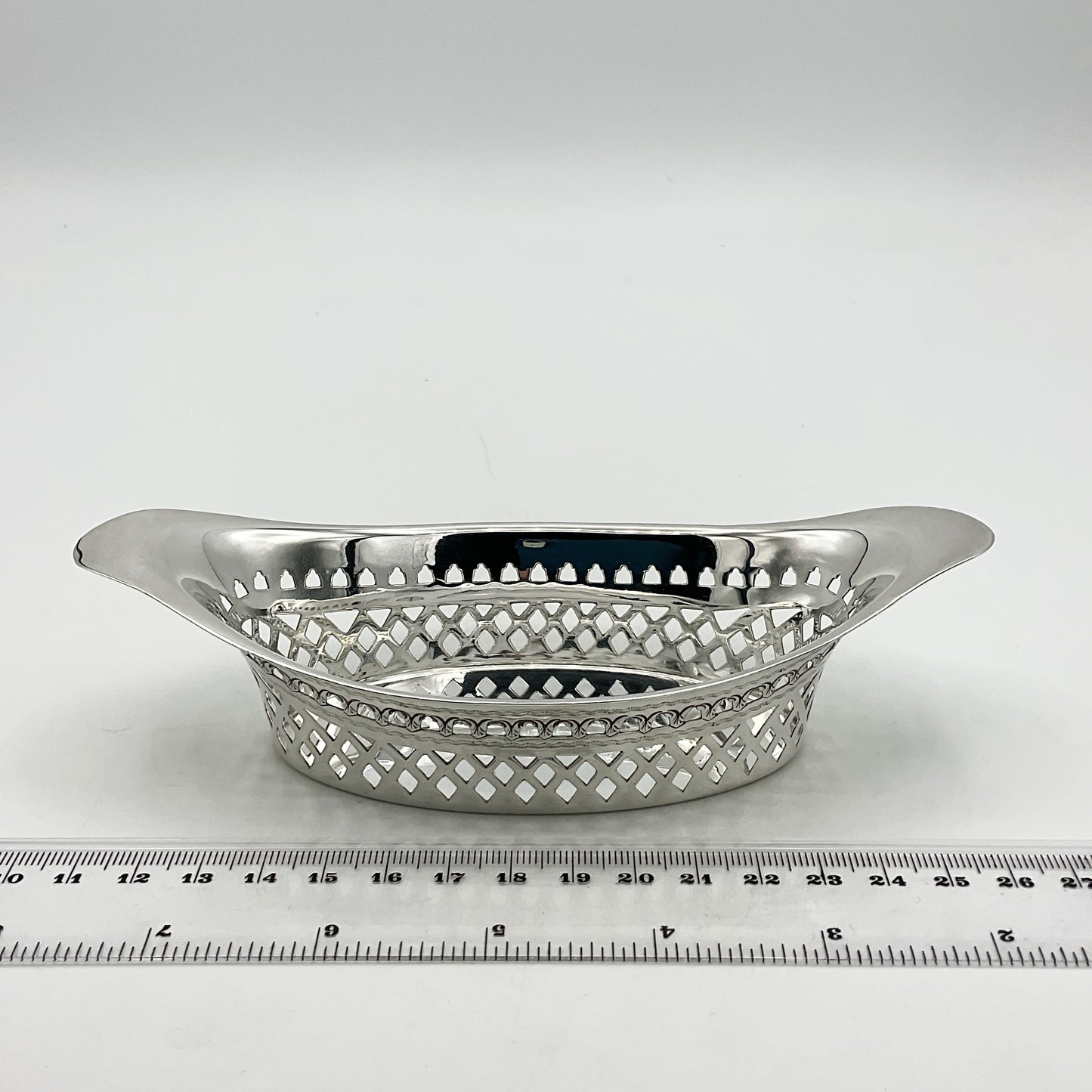 Side view of antique silver pierced bowl and a ruler showing the width as approximately 15cm