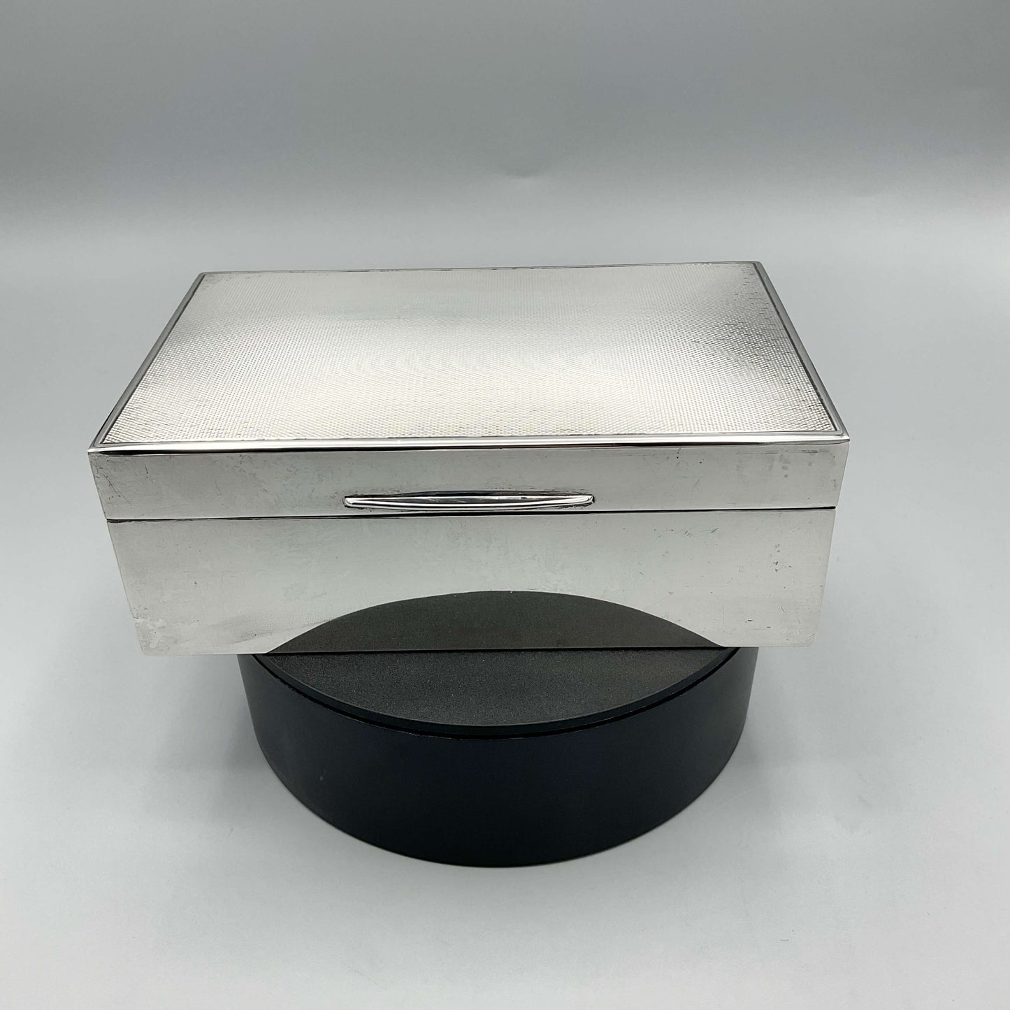 Beautiful Vintage Silver Cigarette Box sitting on  a turntable with a white background