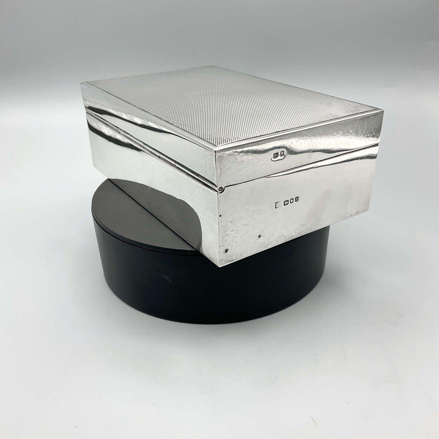 sterilng silver cigarette box with hallmarks and makers mark on the side on a turntable