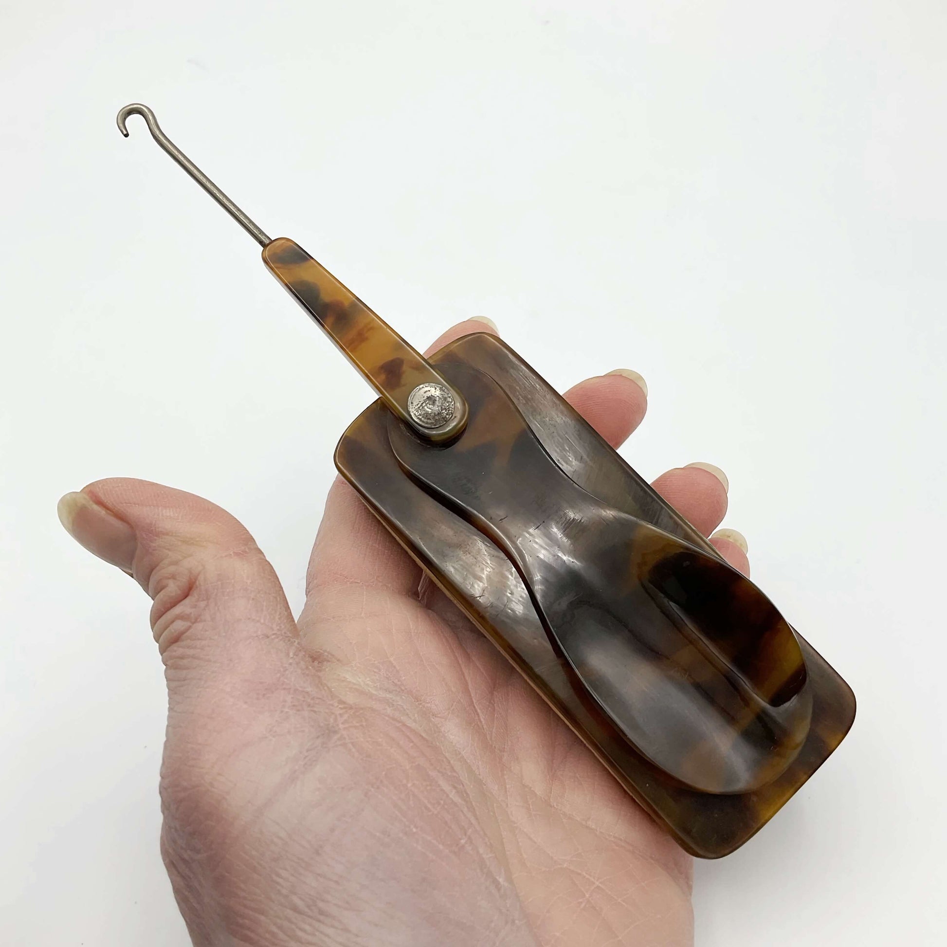 Button hook horn and buffer held in hand