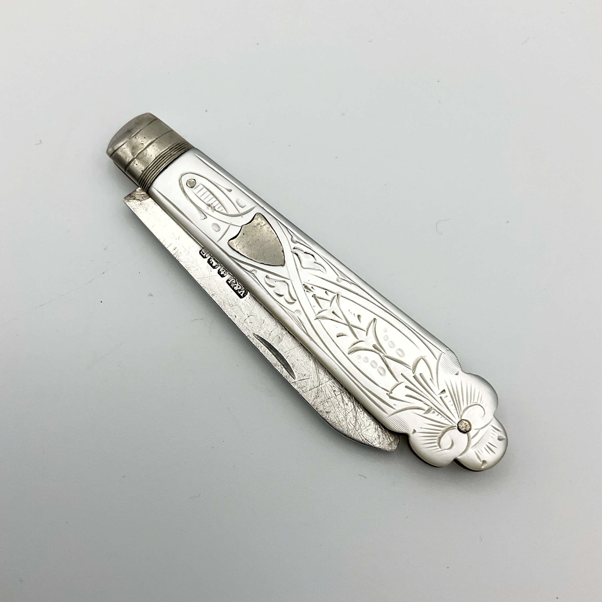 Vintage silver fruit knife with a beautifully engraved mother of pearl handle with the blade folded away into the handle.