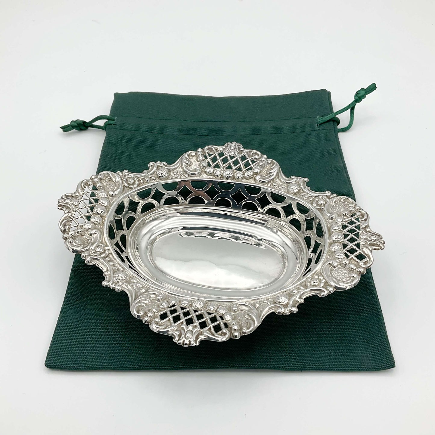 Lovely ornate silver pierced bowl on green gift bag