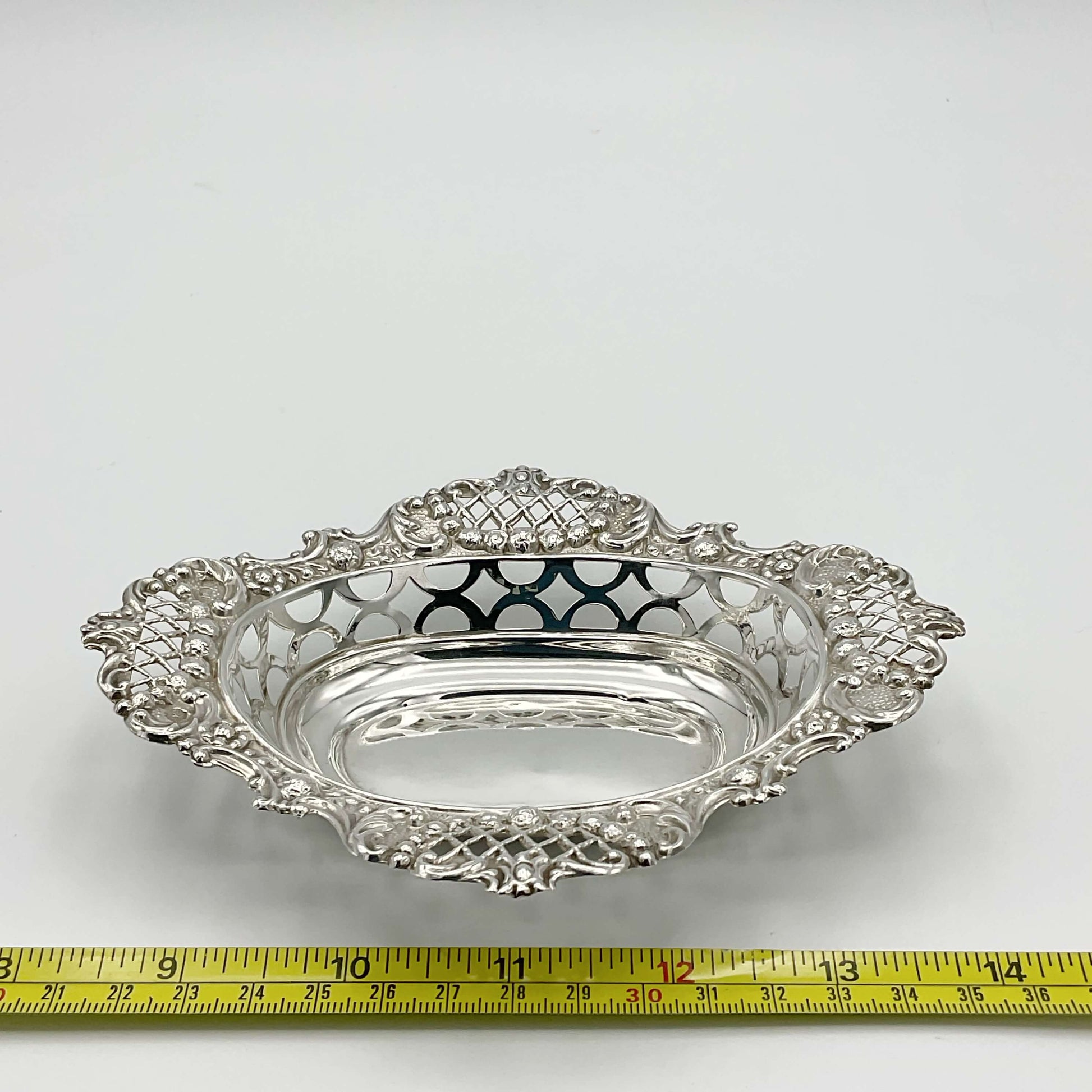 Antique Edwardian silver bowl next to tape measure showing size as 15.5cm