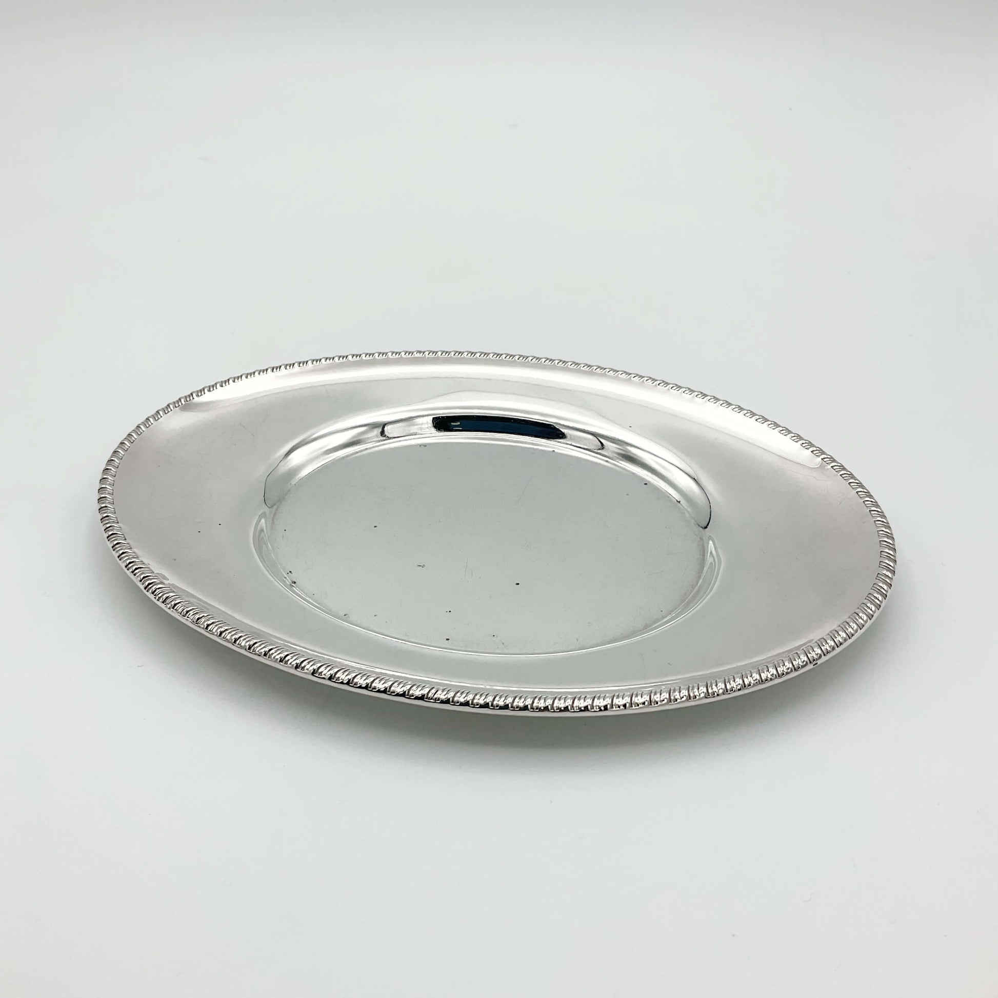 A beautiful shiny silver plated serving tray or platter on a white background